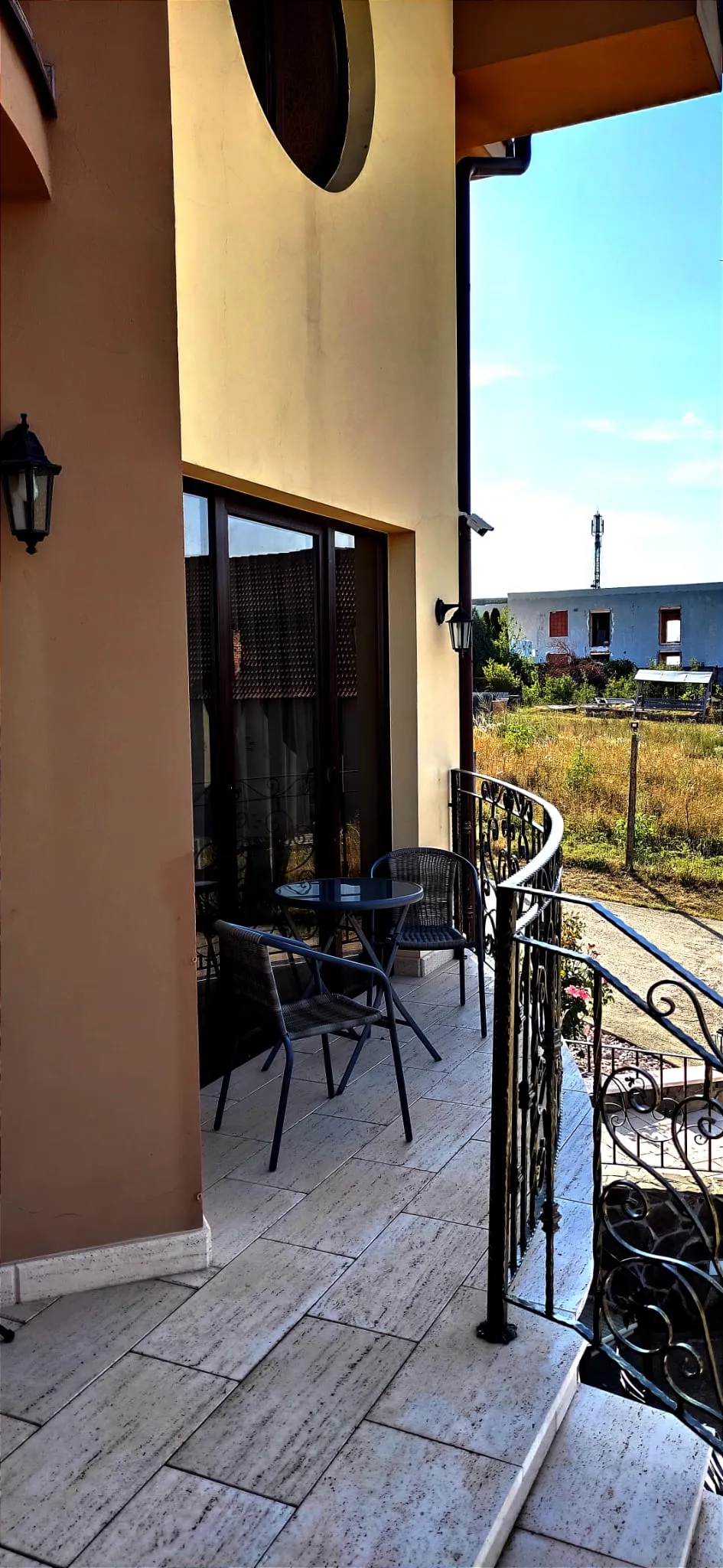 Side balcony with wrought iron and a view over the fields