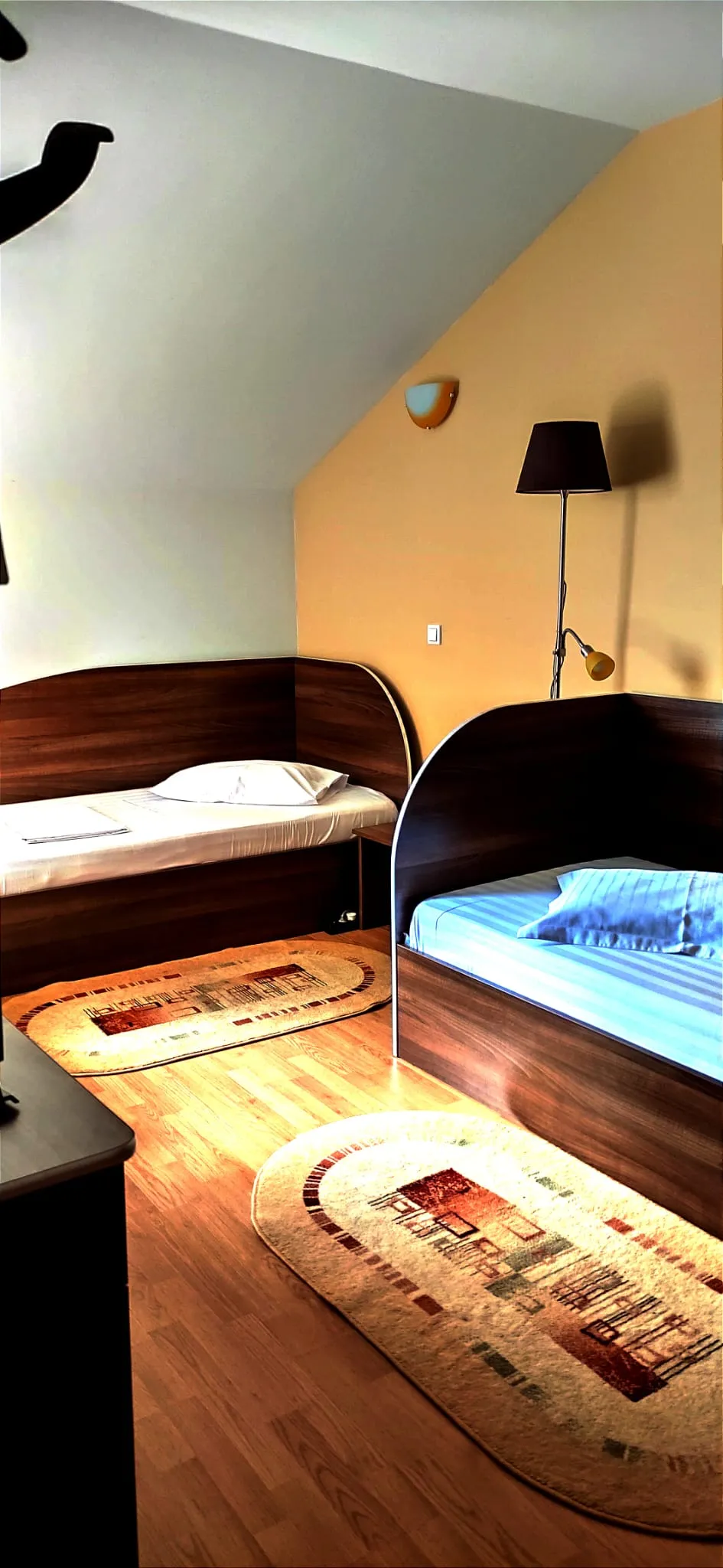 Two-bedroom attic suite with beds and warm natural light